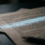 A single line of text lit apart from surrounding blurred text, illustrating how prompt injection hides instructions inside ordinary content
